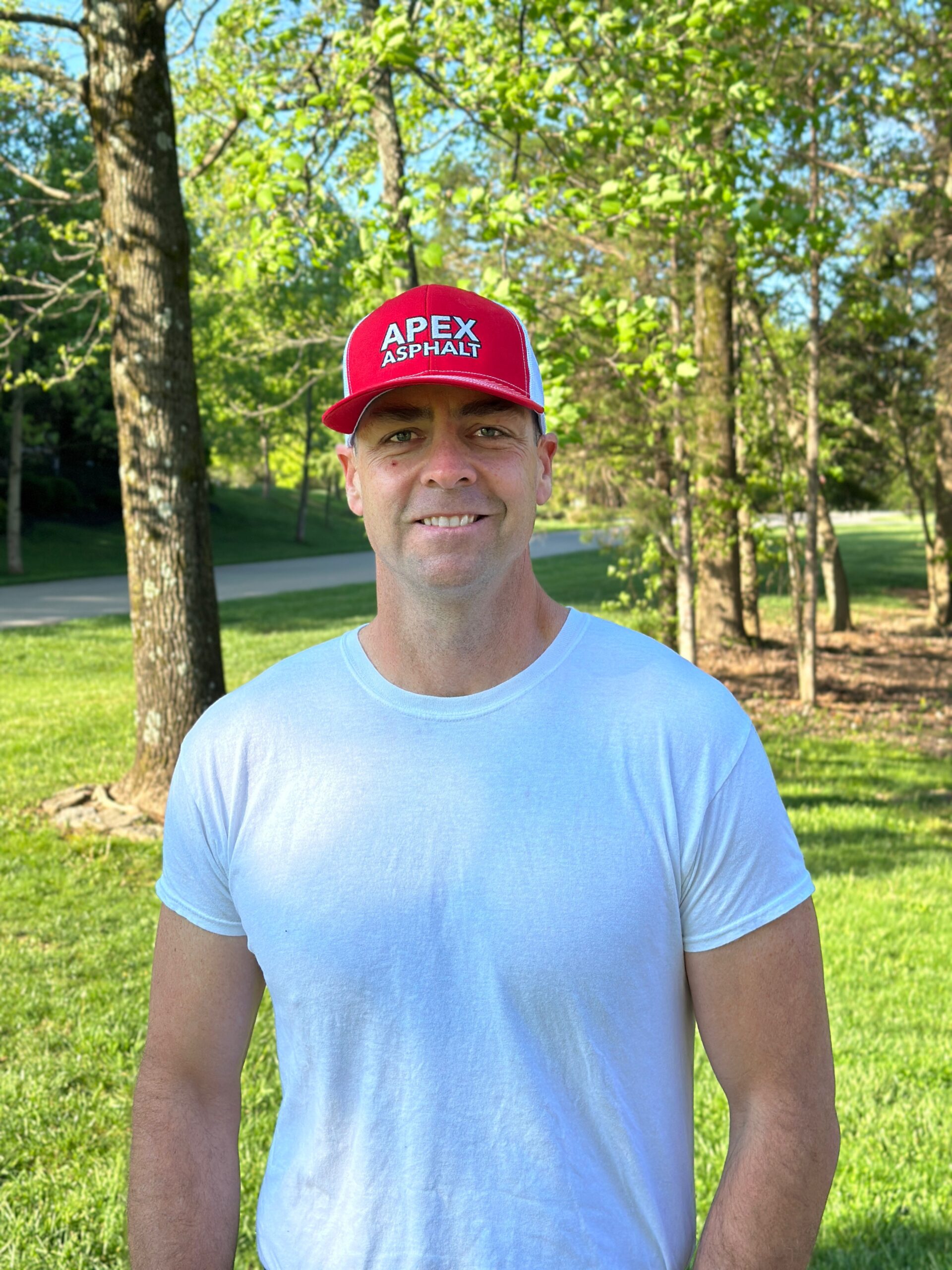 A man in a white shirt and red hat smiling